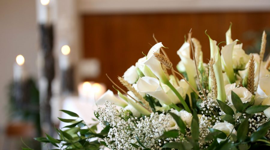 vase of flowers on an altar in the church and the candles on background