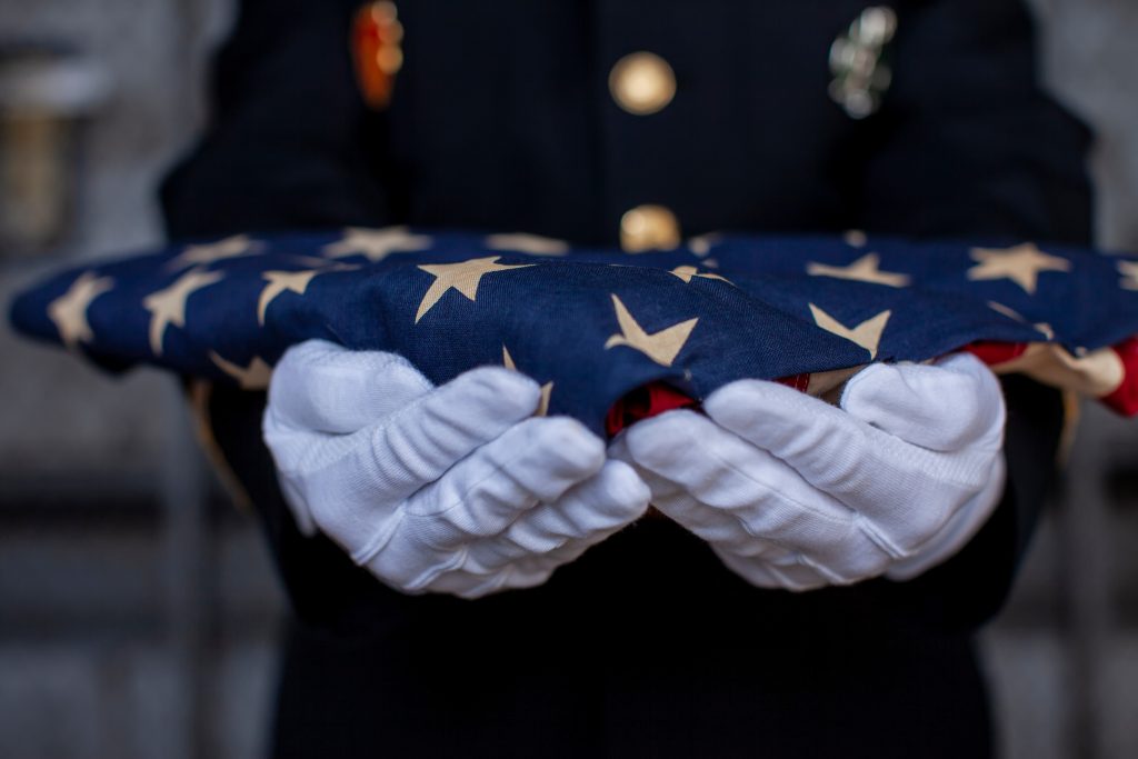 Soldier holding folded American Flag