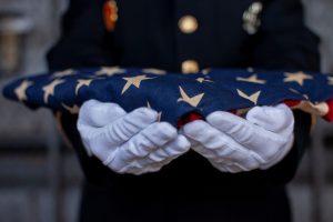 Soldier holding folded American Flag