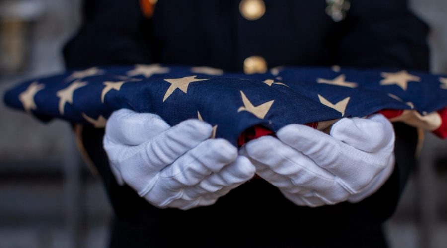 Soldier holding folded American Flag