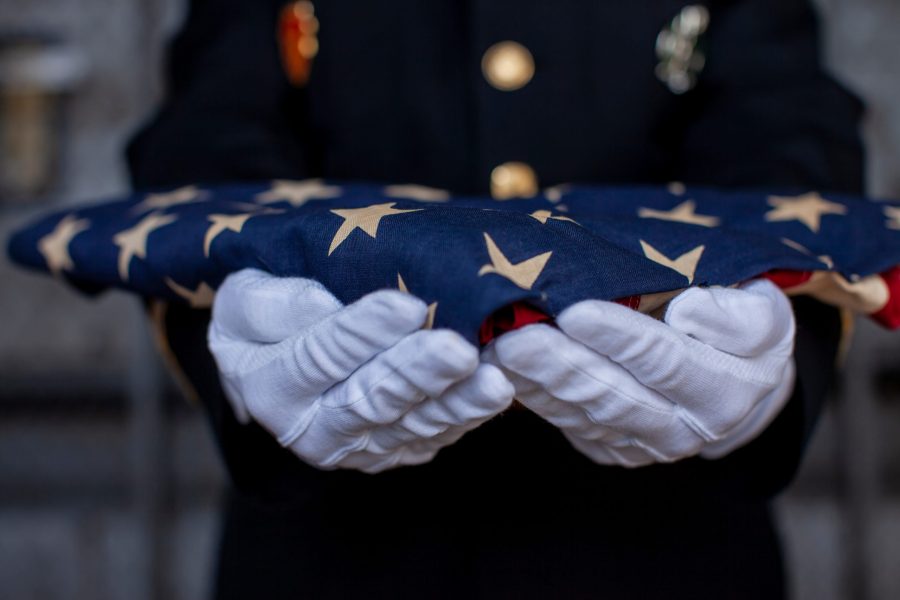 Soldier holding folded American Flag