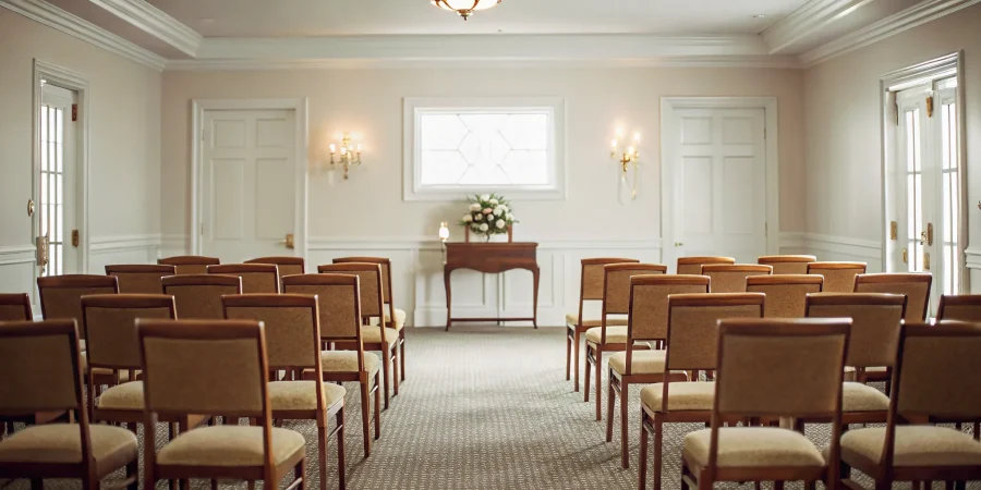 Rows of padded stacking chapel chairs arranged in a professional funeral home chapel