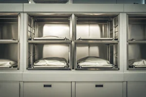 Stainless steel mortuary cooler racks and body trays configured in a facility