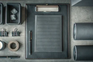 A desk with a notepad and pen for planning a funeral supplies order.